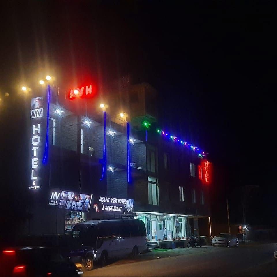 The exterior of Arcadian Hotel & Resort lit up at night